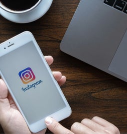 instagram logo on a white iphone help over a brown table