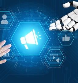 human hand and robot hand reaching out to touch with a hollogram of a megaphone in the middle