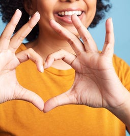 Person making a love heart sign with their hands
