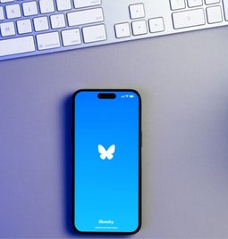 Mobile on a desk showing the Bluesky logo