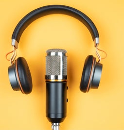 yellow surface with microphone and headphones placed in the center