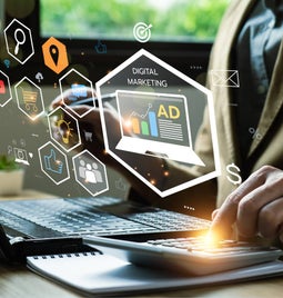 Hands on a desk using a laptop and a calculator