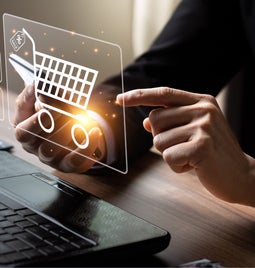 Person pointing at a floating icon of a shopping cart