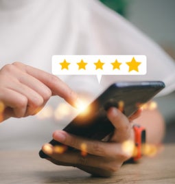 Person using a phone with a floating image above showing a five star rating