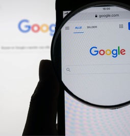 Photo of a desktop and phone with the google chrome browser on screen and a magnifying glass