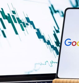 A smartphone on a stand with the Google logo on screen