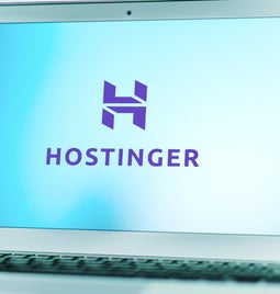 Silver laptop showing the Hostinger logo on the screen