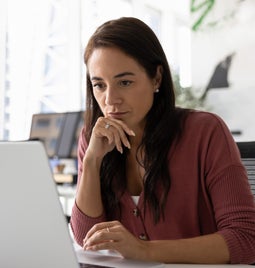 Woman focused as she works at a laptop
