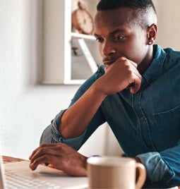 Man concentrating as he looks at a laptop