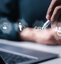 A person uses a stylus on a digital interface displaying icons for online reputation management and user feedback tools.