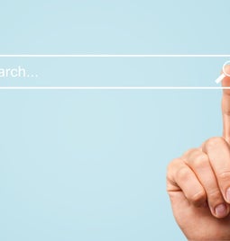 hand pointing to a search bar on a blue background