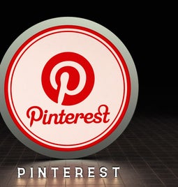 Illuminated Pinterest logo on a dark background, featuring a red circular design with the name 