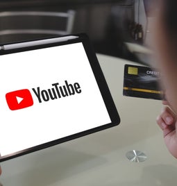 person holding ipad with YouTube logo full screen